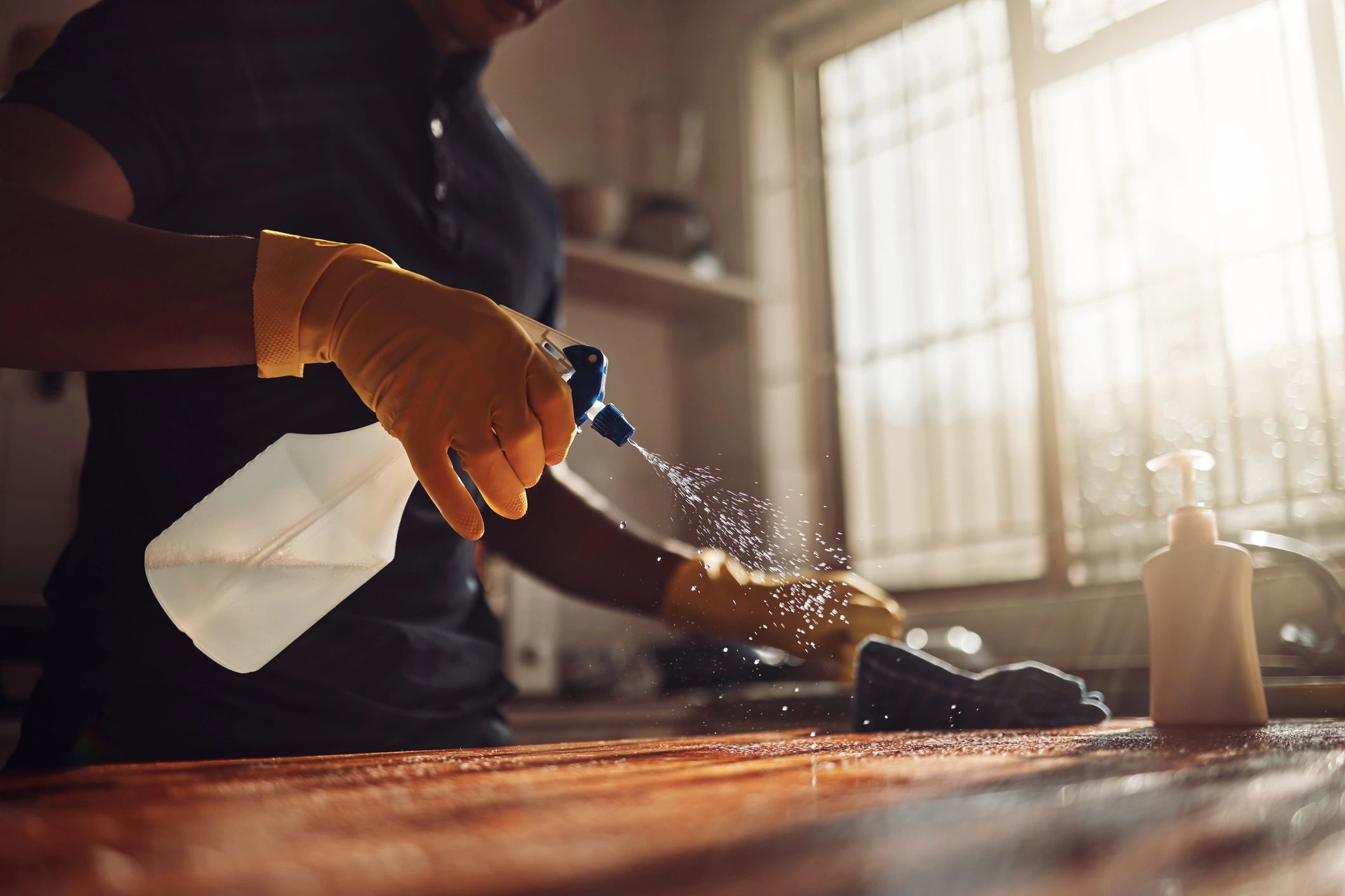 Cleaner disinfecting a kitchen counter